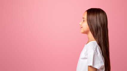 Close eyes for surprise. Smiling girl with long hair isolated on pink background, studio shoot