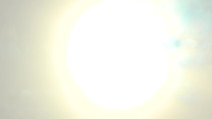 Beautiful and vibrant image depicting the powerful rays of the sun glowing through the clouds moving beneath. Represents shining brightness, energy, and the dynamism of nature's celestial beauty.