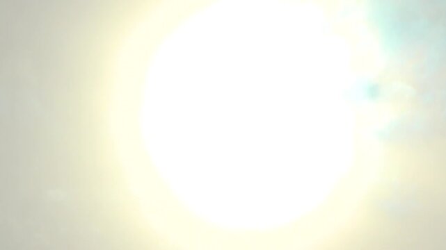 Beautiful and vibrant image depicting the powerful rays of the sun glowing through the clouds moving beneath. Represents shining brightness, energy, and the dynamism of nature's celestial beauty.