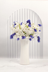 Beautiful still life with white hyacinths and blue muscari in a vase on an elegant modern background,Abstract flower arrangement,template for design and banner for the screen.Spring card,