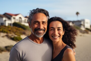 portrait of a smiling middle age hispanic couple in empty home after moving in