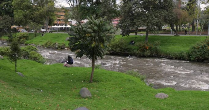 Fast river stream in a town, park by the riverside