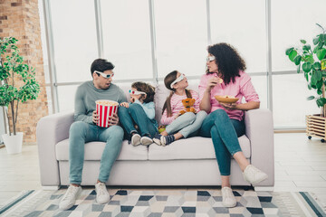 Family enjoying movie time with 3D glasses on a cozy sofa in their bright and modern living room