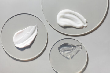 Cosmetic cream and gel and serum set smudge drops swatches on circle transparent clear plastic podium background