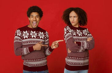Relationship in couple and joke on holiday. Cheerful african americans guy with open mouth points...