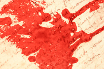 Blood on paper with written text.Red blots and streaks on the letters. Letters in red paint.