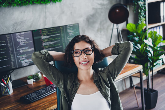Young female programmer enjoying her workspace at home, showcasing a modern and stylish approach to coding and development