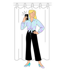 Woman taking selfie in fitting room while trying new outfit