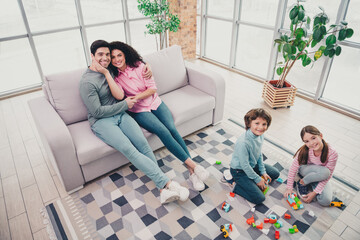 Happy family enjoying quality bonding time indoors with children playing and parents relaxing together