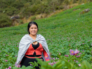 Foto de una feliz campesina caucásica parado en medio de sembrío de papas en Perú ,campesina con un tejido de manta artesanía peruana en la chacra,estilo de vida.Concepto de viaje.