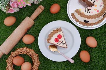 Delicious cake and eggs on green surface
