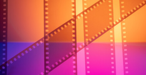 Obraz premium color abstract cinema background with film strip.real 35mm film strip with texture and footage for cinema banner frame postcard ticket flyer announcement