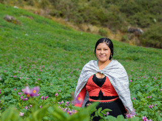 Foto de una feliz campesina caucásica parado en medio de sembrío de papas en Perú ,campesina con un tejido de manta artesanía peruana en la chacra,estilo de vida.Concepto de viaje.