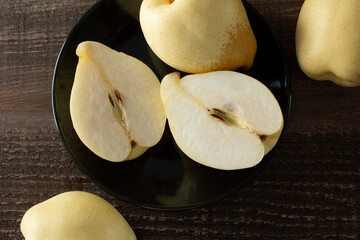 A top down view of a plate of yali pears, featuring one that is halved.