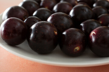 A closeup view of a plate of muscadine grapes.
