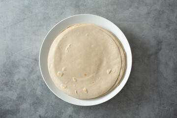 A top down view of a plate of flour style gluten-free tortillas.