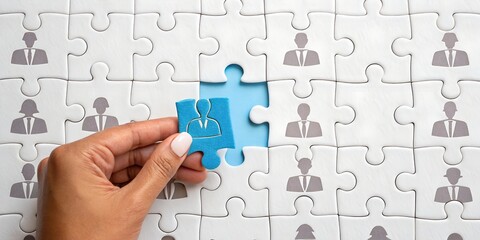 Human Resource: A hand carefully places a puzzle piece into a completed jigsaw, symbolizing the perfect placement within a network. Perfect imagery for human resources or team building