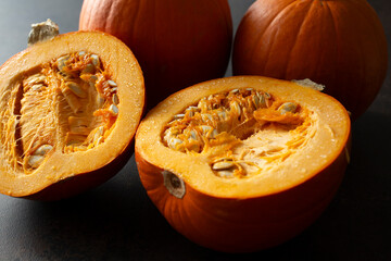 A view of some pie pumpkins, featuring one that is halved.