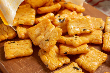 A closeup view of a pile of crispy rice cracker snack spilling out of the bag.