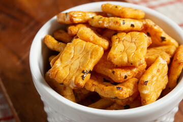 A closeup view of a bowl of crispy rice cracker snack.