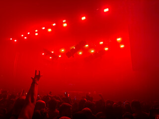 A view of a crowd viewing a DJ performance on stage, featuring stage lights.