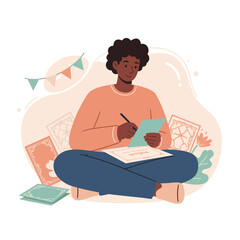 Young person sitting cross-legged writing on tablet with books and decorative flags around in cozy space 