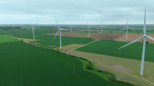 Aerial drone view renewables wind turbines energy electricity gas coal fossil fuels green rural fields generation England UK Biggleswade 