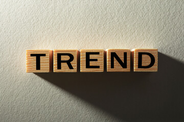 Word Trend made of wooden cubes with letters on white textured background, top view