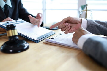 A male executive and female colleague discuss documents in a corporate office, demonstrating leadership, collaboration, and professional teamwork in a business agreement setting.