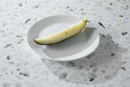 A view of a dill pickle on a plate.