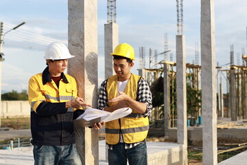 A diverse group of architects, engineers, and business professionals exchange a handshake indoors, symbolizing teamwork, success, and cooperation in a construction industry agreement.