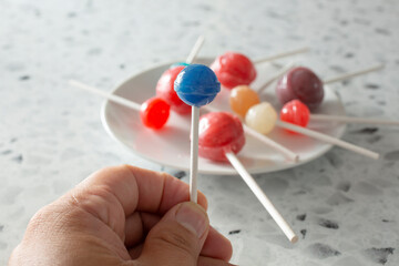 A view of a hand holding a lollipop.