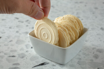 A view of a hand pulling out a gluten-free water cracker.
