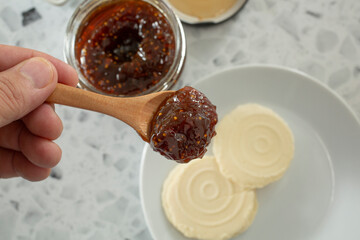 A top down view of a hand holding a spoonful of fig spread.