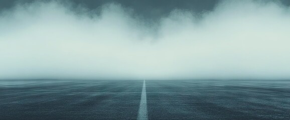 Misty road scene with center line on pavement disappearing into thick fog background