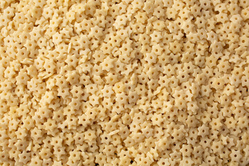 A top down view of a pile of dry star shaped pasta, as a background.
