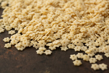A closeup view of a pile of dry star shaped pasta.