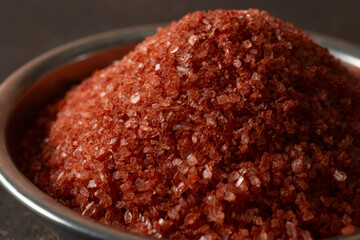 A closeup view of a condiment cup of Hawaiian red salt.