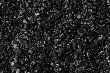 A top down view of a pile of black sea salt, as a background.