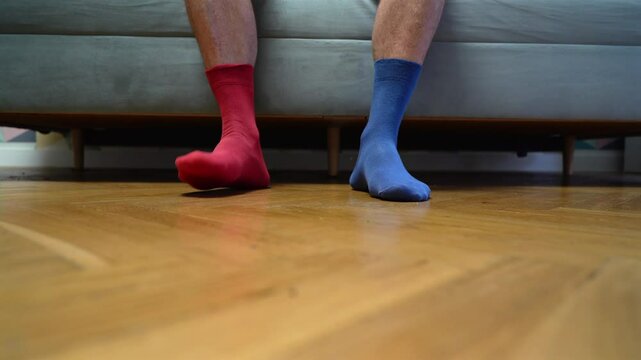 Different socks in legs. Mismatched multicolored socks on feet man. Men's legs in Different socks as symbol of down syndrome. Down syndrome awareness concept. Wear Mismatched Socks. Disabled person.