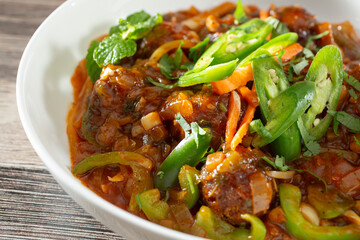 A closeup view of a bowl of chicken Manchurian.