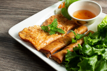 A view of a plate of fried bean curd and egg rolls.