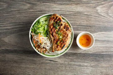 A top down view of a bowl of Vietnamese bun, featuring grilled chicken.