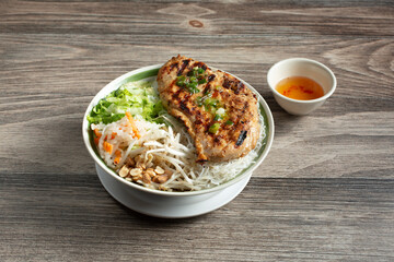 A view of a bowl of Vietnamese bun, featuring grilled chicken.
