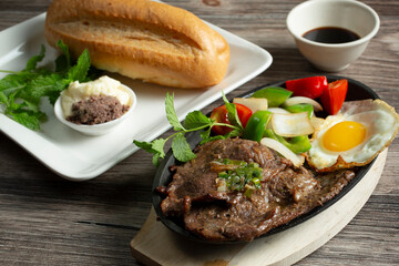 A closeup view of a Vietnamese steak and eggs entree.
