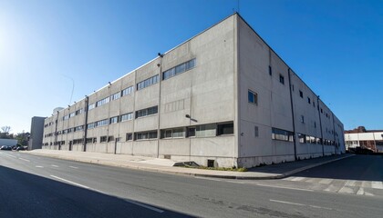 Obraz premium Modern Industrial Building with Clear Blue Sky and Asphalt Road