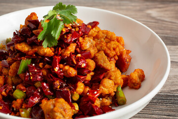 A closeup view of a plate of spicy popcorn chicken.