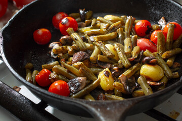 A closeup view of sauteed green beans in a cast iron skillet.