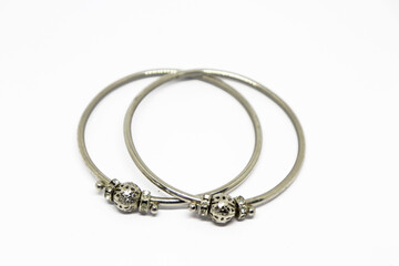 Two silver Indian bangles with decorative accents isolated on a white surface