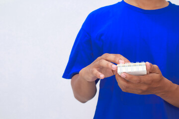 Man in Blue Shirt Handling a Small White Notebook with Spiral Binding